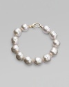 An elegant strand of white organic pearls, with a graceful clasp. 14mm white baroque man-made pearls Length, about 8 18k goldplated sterling silver spring clip clasp Made in Spain