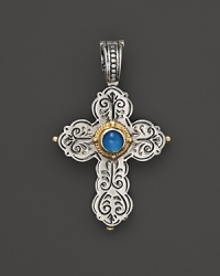 An intricately engraved sterling silver cross pendant embellished with an aquamarine stone and 18K yellow gold.