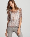 Channel modern bohemian style in this Sam & Lavi top, flaunting an eclectic print and billowy high/low hem.