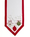 All the trimmings. Prepare for a jolly-good time with the Holiday Ornaments runner, featuring a simple white cloth festooned with holly embroidery, colorful ornaments and red trim.