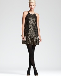 Alluring metallics illuminate an intricate lace silhouette for a simply stunning DKNY dress. Showcase the ruffled hemline against sheer black tights and ignite the night.