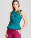 A jewel-colored Trina Turk top featuring a classic peplum waist for ladylike charm, rendered in luxurious woven silk.