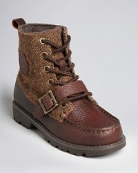 A rugged work boot is embellished with a herringbone fabric upper, soft lining and buckle strap detail above the toe.