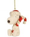 Adorable Snoopy poses with a festive candy cane and glittering Santa hat in this lovely porcelain ornament from Lenox. With gold hanging thread.