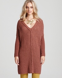 A loose-knit Free People sweater in a warm, autumnal hue slips on for easy weekend style. Dolman sleeves and seam detail lend modernity to the look, trend-right with colored cords and ankle booties.