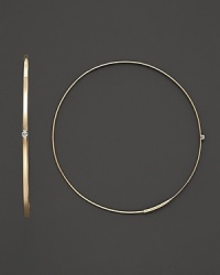 A graceful hoop in yellow gold with diamond accent and invisible closure to create a perfectly elegant orb to complement your most refined ensembles. Designed by Lana.