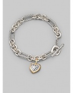 From the Cable Heart Collection. A bold chain, combining smooth and cable links, holds a lovely cable heart charm, framed in 18k gold. Sterling silver and 18k yellow gold Length, about 7½ Toggle closure Imported