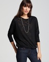 This ALTERNATIVE top goes beyond basic, with modern details like dolman sleeves and a crossover, deep v back.