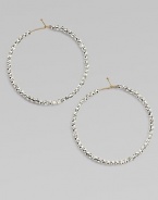 Hoops of 14k gold wire are set with faceted sterling silver beads that catch and reflect light with a warm radiance.14k yellow gold and sterling silverDiameter, about 1½Ear wireMade in USA