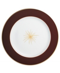 A rich burgundy rim frames a single gold starburst in the center of this striking service plate from Bernardaud.