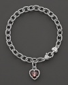 A faceted raspberry crystal heart charm decorates a classic bracelet from Judith Ripka.