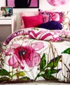 Two chic decorative pillows embellish your Teen Vogue Flora and Fauna bed, featuring a coordinating white and pink zebra stripe pattern and a floral ruffle design in a deep purple hue.