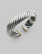 From the Carved Cable Collection. A bold cable cuff of sterling silver, richly accented with touches of 18k gold. Sterling silver and 18k yellow gold Cable, 15mm Diameter, about 2¼ Hinged Imported