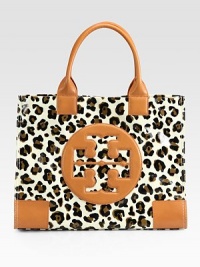 A signature logo is at the center of this coated leopard-print canvas design with warm leather trim. Double leather top handles, 7 dropMagnetic snap closureOne inside zip pocketTwo inside open pocketsCanvas lining17W X 13H X 5¾DImported