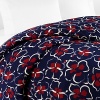 Moonlight silhouettes tropical dancing garlands on this DIANE von FURSTENBERG fill/queen duvet cover, in cool, soothing navy with red and white details.