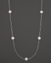 White mother-of-pearl floral stations punctuate this sterling silver link necklace from Lagos.