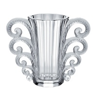 In 2010, to celebrate the 150th anniversary of René Lalique's birth in 1860, LALIQUE created the Hommage à René Lalique collection. In this collection, Lalique re-examines and reinterprets iconic glass creations of Rene Lalique. The Beauvais vase, created in 1931, is reissued in clear crystal. The manufacturing process truly requires the technical expertise of more than 10 glass masters. It is particularly difficult to shape the openwork crystal volutes and decorate both sides of the parison. To obtain the contrast of satin-finished and shiny crystal, characteristic of Lalique, the glass masters, as sculptors of light, detailed by hand each detail of the vase. The beauty of the artist-craftsman's motions serves his search for excellence.