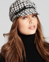 A two-tone houndstooth print and synthetic leather bow add edge to this conductor-style cap from August Accessories.