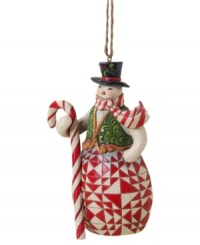 Carrying a candy cane staff to match his scarf, this crafty snowman plays it cool with elaborate carved and quilt-patterned detail in the signature folk-art style of Jim Shore.