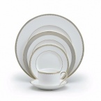 Rings of gold adorn fine white bone china with the lustrous shine of a wedding band. White bone china features two different border trims of gold, a wide corded border of textured grosgrain ribbon on some pieces, a narrow edge on others.