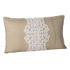 A silk decorative pillow with a Moroccan-inspired rope applique.