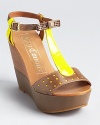 Neon lemon leather is mixed with neutral stone on these Juicy Couture wedges, showcasing perforation and bow details.