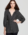 Delicate polka dots dance across an Isaac Mizrahi Jeans top, cinched at the waist for a demure yet dramatic look.