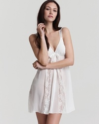 Elegant lace panels and a large bow decorate this lovely sleeveless chemise from Oscar de la Renta.