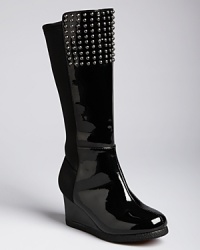 A girlie wedge with rockin' edge, this flashy patent leather boot features a dramatic wedge rise and studs at the top.