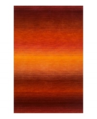 Imparting warm visions of brilliant sunrises on the horizon, this deeply textured rug features intense tones of red and orange that recall a perfect morning sky. Hand-tufted and color blended with the greatest of care, this wool rug comes alive with texture and color.