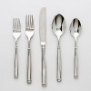 A clean, traditional flatware assortment with banded handle detail and brilliant mirrored finish by Ginkgo. Set includes eight, 5-piece place settings and set of 5 serving pieces (a pierced serving spoon, a serving spoon, a cold meat fork, butter knife and a sauce ladle). Dishwasher safe.