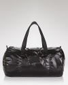 A shiny padded duffel infuses your travel with sleek modern style, a dynamic collaboration between form and function from MARC BY MARC JACOBS.