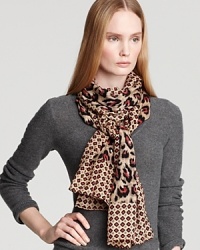 Tie on the trend in Tory Burch's eye-catching animal-print scarf, mixed with a geometric border and unexpected hues.