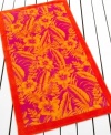 A bold pattern of tropical flowers is framed by a solid border in this beach towel from Lauren Ralph Lauren, featuring a sizzling palette of orange, yellow and pink.