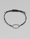 A knotted cord with a black diamond encrusted, 18K rose gold, oval link. Black diamonds, .25 tcw18K rose goldPolyester cordLink size, about ¾Length, about 13½ adjustableDrawstring closureImported 