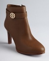 Tory Burch ups the style quotient on the basic bootie in these sleek shoes featuring almond toes, polished leather and elegant logo accents.