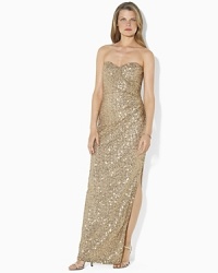 A stunning foundation of sequins imparts sexy sophistication to a sweeping floor-length gown, designed in a sleek faux-wrap silhouette with elegant ruching and a dramatic slit at the hem.