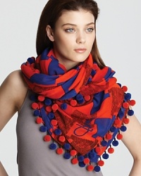 Make a statement with this cozy scarf featuring a colorful weave of red and blue abstract check and matching ball trim.