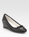 An elevated self-covered wedge silhouette of patent leather, topped with a pretty grosgrain bow. Self-covered wedge, 1½ (40mm)Leather and grosgrain upperLeather liningRubber solePadded insoleMade in France