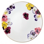 Pensees service plate by Bernardaud. This lively, luxurious collection is sure to transform your table into a celebration of spring. The floral watercolor pattern features delicate, multicolored pansies that appear to be strewn across the surface of each piece.