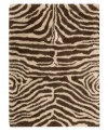 Exotic designs will be the pride of your decor. Adorned with zebra stripes in ivory and brown, this Nourison rug has a marvelously soft and shaggy pile that's hand-tufted from premium-quality yarns. Beautiful in appearance and plush underfoot, this area rug creates an atmosphere of casual elegance. (Clearance)