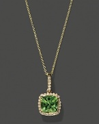 Diamonds frame a faceted peridot, set in 14K yellow gold.