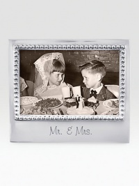 A fitting setting for wedding photos, hand-crafted of recycled aluminum with etched Mr. & Mrs. inscription along the bottom.Accommodates a 4 X 6 photoRecycled aluminum6.75W X 5.75HWipe cleanImported