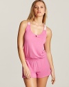 A sporty romper gets a girlish touch with floral lace racerback, straps and patch pocket at back.