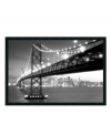 San Francisco's Bay Bridge takes center stage in this elegant black and white print, while the city's skyline glitters softly in the distance. With its easily recognizable landmark and unique perspective, the framed piece lends urban panache to your home.