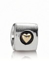 A polished sterling silver PANDORA charm with a 14K gold heart center.