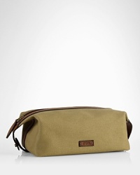 An impeccably stylish carrying case for the modern gentleman, this lightweight pouch provides sharp transport for essential toiletries in a leather-trimmed canvas construction.