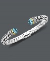 Cuff love. Pretty round-cut blue topaz (7 ct .t.w.) and sparkling diamonds (1/10 ct. t.w.) adorn the ends of this stunning open-cuff bracelet. Set in sterling silver with 14k gold accents. Approximate length: 7 inches.