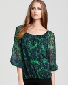 A lush floral print invigorates this peasant-style Alice + Olivia top, rendered in pure silk, with the essence of fall.