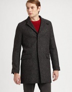 A Japanese wool coat with an elongated silhouette and concealed button closure. Notched collarConcealed button closureFlap pocketsAbout 35 from shoulder to hemWoolDry cleanImported